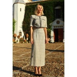 Mujer de frente luciendo traje formado por una camisa de manga corta elegante