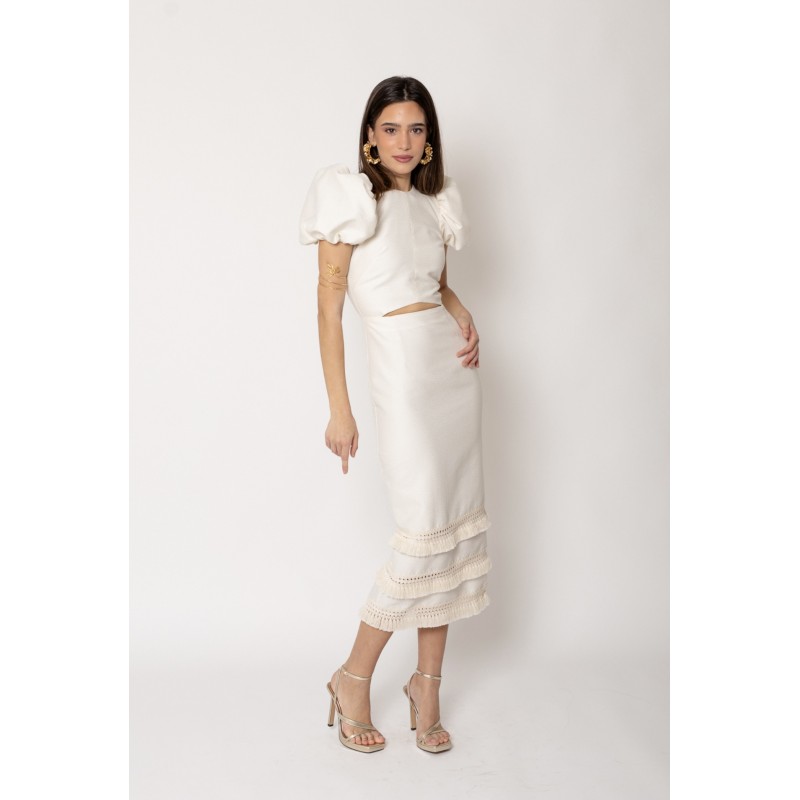 Mujer luce un vestido midi, de color crema y con mangas abullonadas