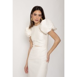 Mujer posando luce un vestido midi color crema con mangas abullonadas