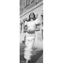 Mujer luce un vestido de corte recto, color crema y con detalles de flecos bordados al final