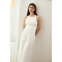 Mujer apoyada con vestido blanco sofisticado