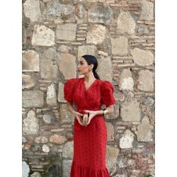 Mujer luciendo vestido midi rojo con escote en pico y mangas abullonadas, mirando a un lateral